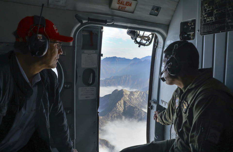 In this Sept. 10, 2018 photo provided by the Peruvian government, President Martin Vizcarra, left, travels in a helicopter to Trujillo, Peru. On a typical day, Vizcarra is up by 5 a.m. and reading the newspapers. Determined to extend his reach through some of Peru's remote lands, he is making a point to travel outside Lima twice a week, deciding where to go by asking aides which towns a president has never visited. (Andres Valle/Andina News Agency via AP)