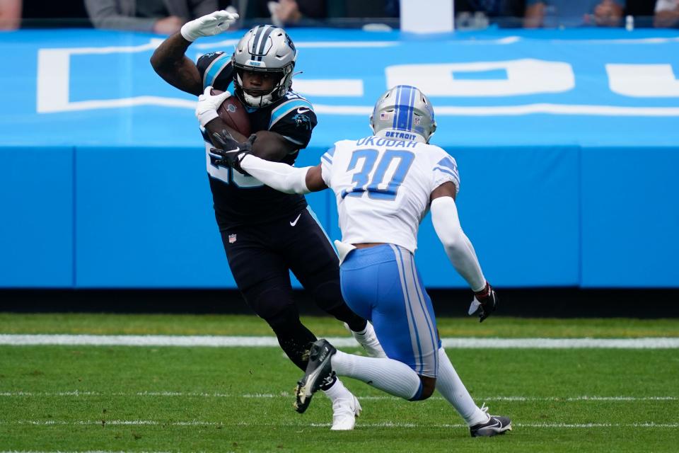 Panthers running back Mike Davis runs past Lions cornerback Jeff Okudah during the first half on Sunday, Nov. 22, 2020, in Charlotte, N.C.