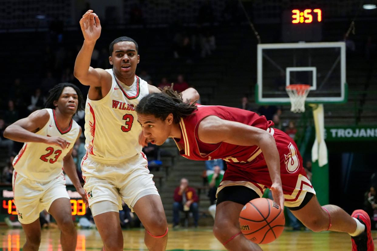 Jeffersonville Red Devils Tre Singleton (0) drives the lane as Lawrence North Wildcats Brennan Miller (3) defends, Saturday, March 16, 2024, during the IHSAA Class 4A semistate game at New Castle High School in Newcastle, Indiana. The Jeffersonville Red Devils defeated the Lawrence North Wildcats, 62-60.