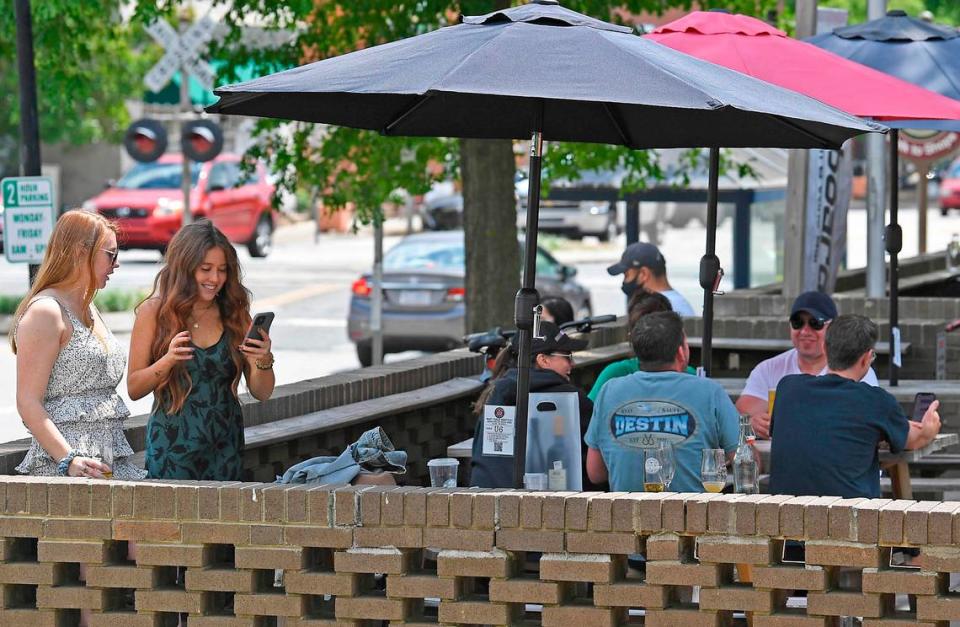 Customers enjoy themselves on the patio at Seaboard Brewing Taproom and Wine Bar in Matthews on Friday, May 14, 2021. North Carolina Gov. Roy Cooper on Friday lifted most mask mandates, effective immediately, signaling an accelerated path to pre-pandemic “normal.”