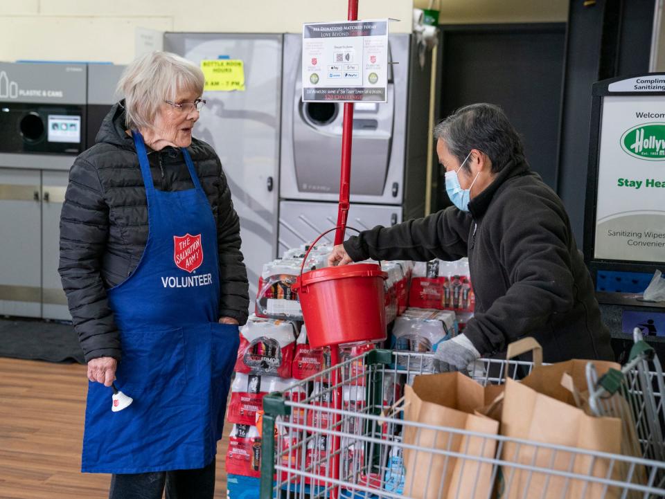 Sue Hilty, 80, of Bloomfield Hills, left, thanks a gift-giver as she volunteers for the first time to ring the bell for the annual Salvation Army Red Kettle Campaign on Dec. 14, 2022, at the Hollywood Market in Troy.