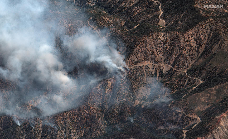 This natural color photo provided by Maxar Technologies shows fire spots from the Bobcat Fire amid an area of the Angeles Crest Highway winding through the San Gabriel Mountains, in Los Angeles County, California, Monday, Sept. 21, 2020. (Satellite image ©2020 Maxar Technologies via AP)