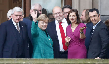 Leader of the German Green Party Cem Ozdemir and leader of the Christian Democratic Union of Germany (CDU) Angela Merkel accompanied by the politicians of their parties are seen on the balcony of German Parliamentary Society offices prior to the exploratory talks about forming a new coalition government held by CDU/CSU in Berlin, Germany, October 18, 2017. REUTERS/Fabrizio Bensch