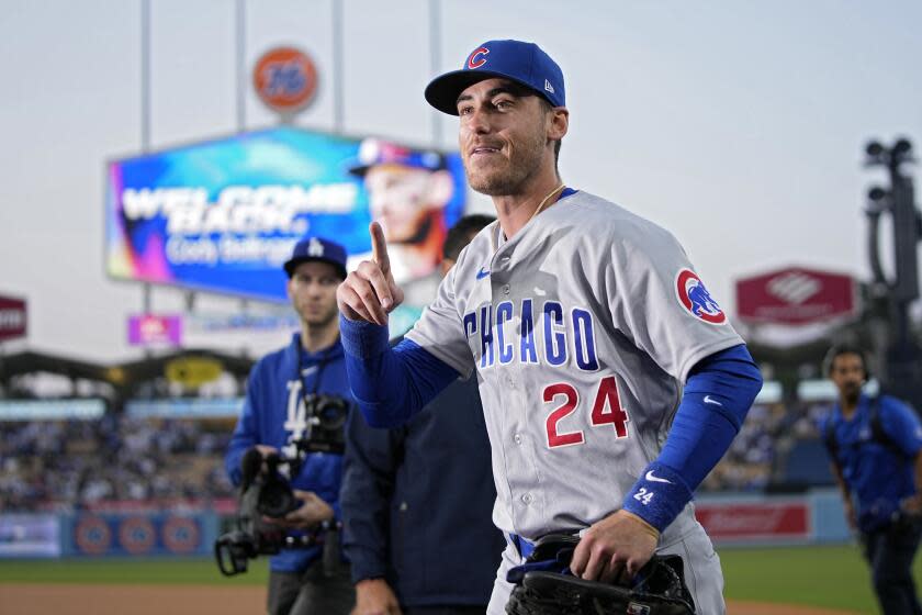 Cubs center fielder Cody Bellinger gestures to the crowd after being acknowledged by the Dodgers prior to a baseball game.