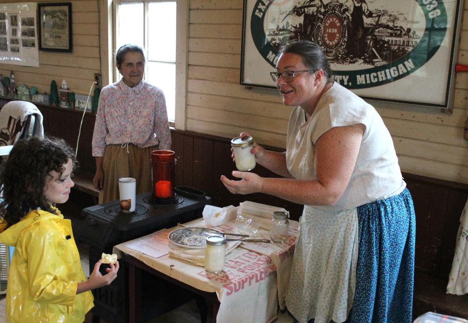 Homeschool second grader Ellie Ferrell (left) and Catherine Fix of Monroe listen as Stacy Nunn of Exeter Township explains how to make butter using a jar and whipping cream.