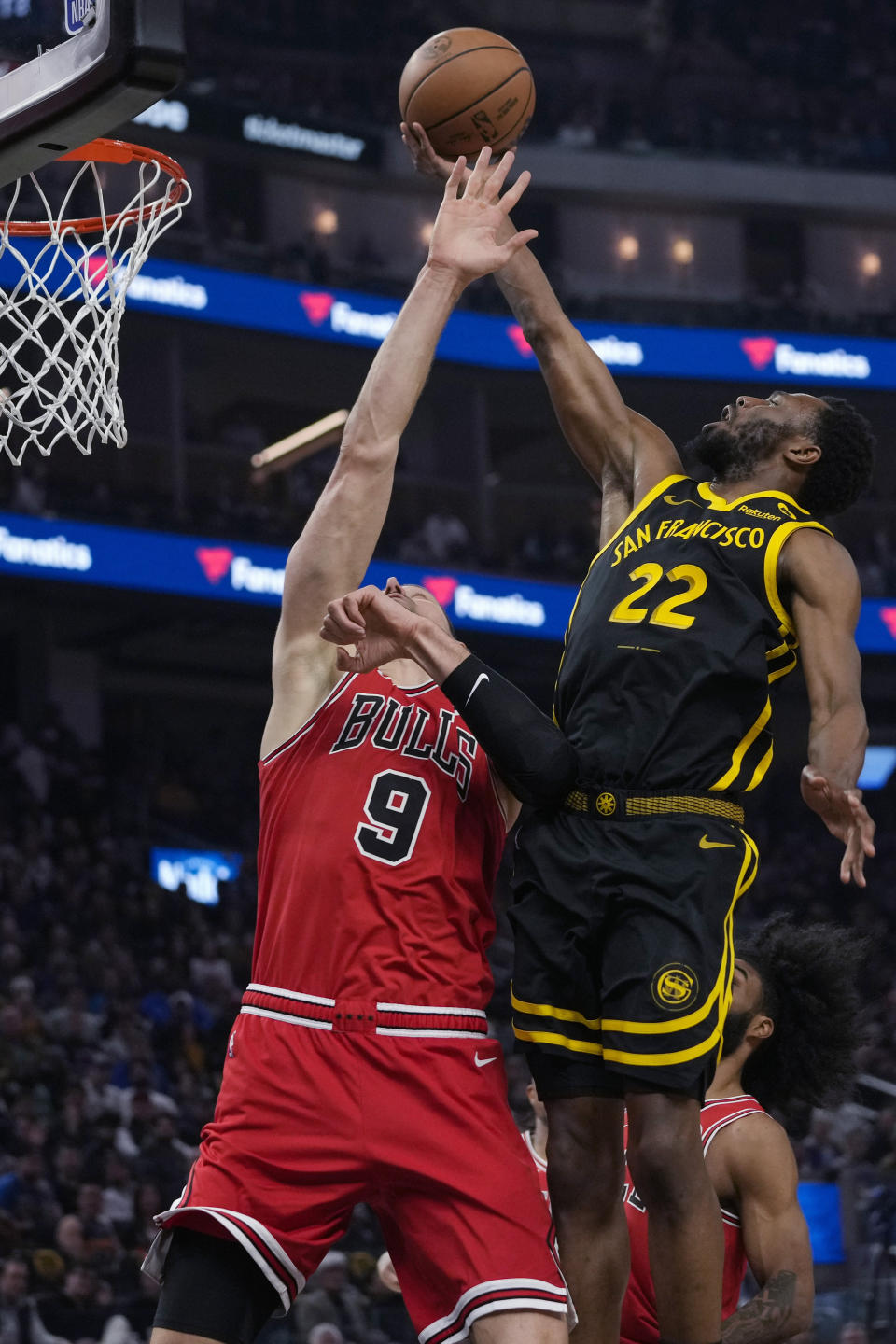 Golden State Warriors forward Andrew Wiggins, right, shoots while defended by Chicago Bulls center Nikola Vucevic during the first half of an NBA basketball game Thursday, March 7, 2024, in San Francisco. (AP Photo/Godofredo A. Vásquez)