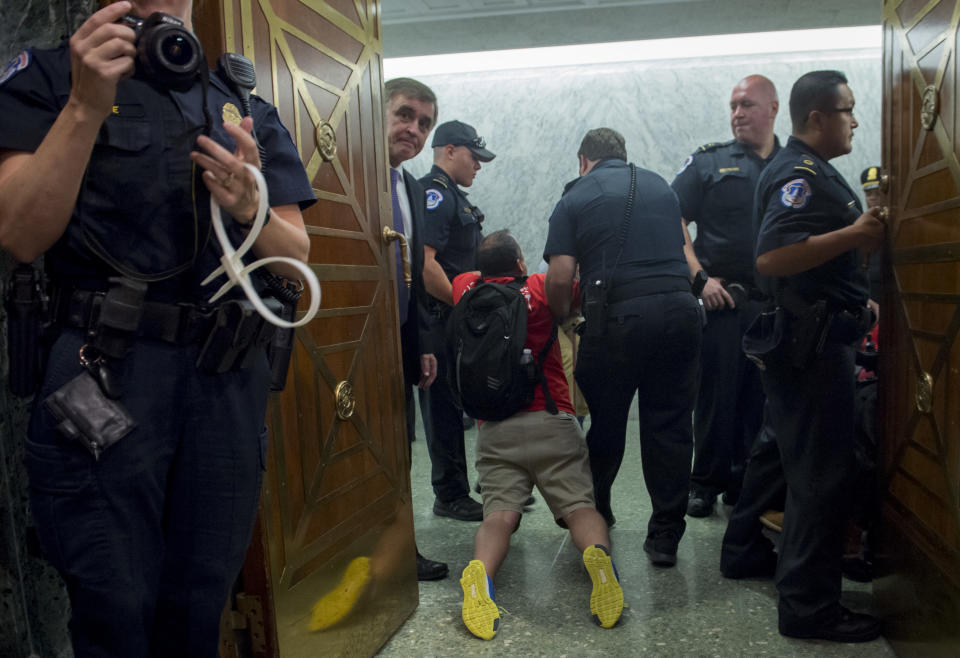 <p>US Capitol Police remove protestors from the US Senate Committee on Finance hearing on the Graham-Cassidy-Heller-Johnson Proposal on reforming health care on Capitol Hill in Washington, DC, September 25, 2017.(Photo: Saul Loeb/AFP/Getty Images) </p>