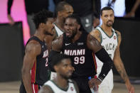 Miami Heat's Jimmy Butler (22) and Jae Crowder (99) celebrate in front of Milwaukee Bucks' George Hill, right, in the second half of an NBA conference semifinal playoff basketball game Friday, Sept. 4, 2020, in Lake Buena Vista, Fla. (AP Photo/Mark J. Terrill)