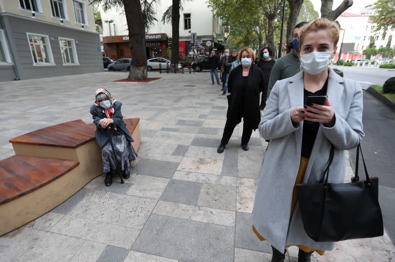 People line up outside a polling station during a parliamentary election in Tbilisi