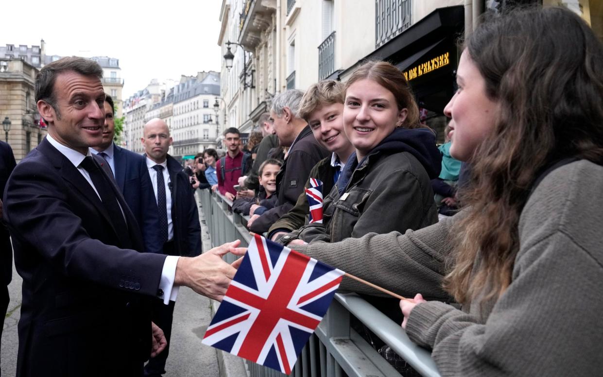 Mr Macron shakes hands with onlookers outside the Elysee Palace