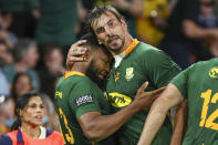 South Africa's Lukhanyo Am, left, is congratulated by teammate Eben Etzebeth after scoring a try during the Rugby Championship test match between the Springboks and the Wallabies in Brisbane, Australia, Saturday, Sept. 18, 2021. (AP Photo/Tertius Pickard)