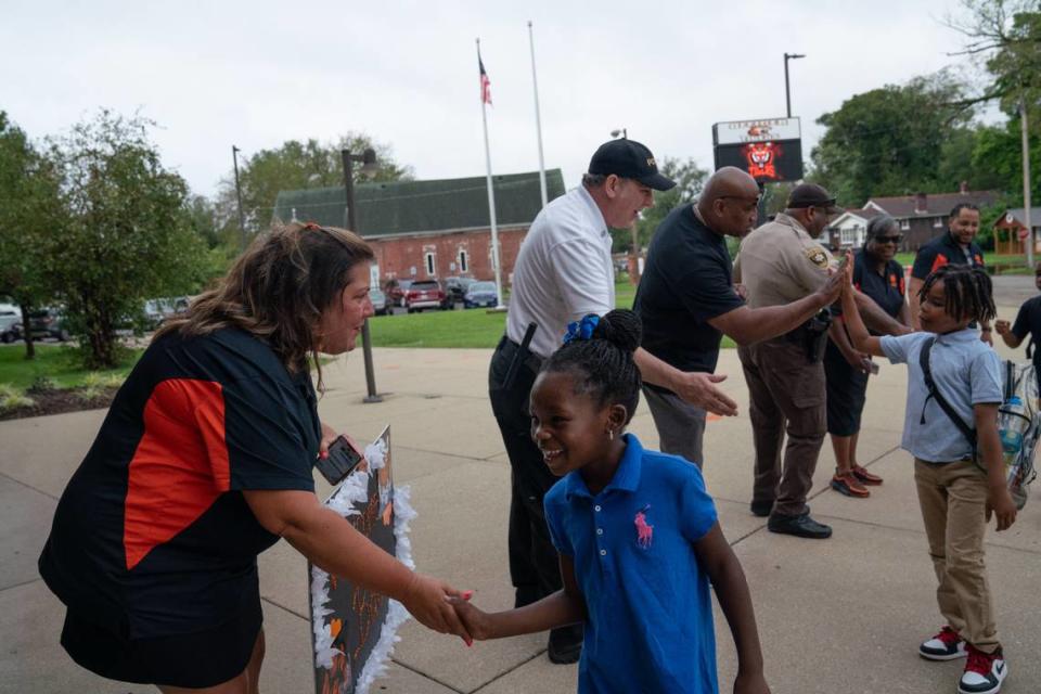 (L-R) Elizabeth Glascock, officer Nicholas Mueller, and East St. Louis NAACP vice president George McClellan give high-fives to students during Officer Elementary’s first day of school. Lincoln Middle School and Officer Elementary opened on the same day, each filled with staff and community partners cheering on students as they entered the building.