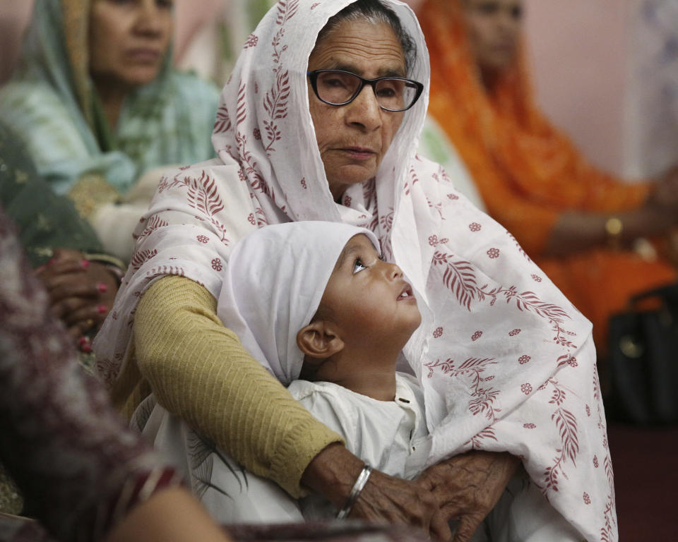 ***HOLD FOR RELIGION TEAM STORY*** Amar Kaur and grandson Ibadat Singh listen during the Shri Guru Ravidass Sabha ceremony at a temple in Fresno, Calif. Sunday, May 7, 2023. Members of the Ravidassia community in California are followers of Guru Ravidass, a 14th century Indian guru of a caste formerly considered untouchable. The Ravidassia community statewide is advocating for new legislation to outlaw caste-based discrimination. (AP Photo/Gary Kazanjian)