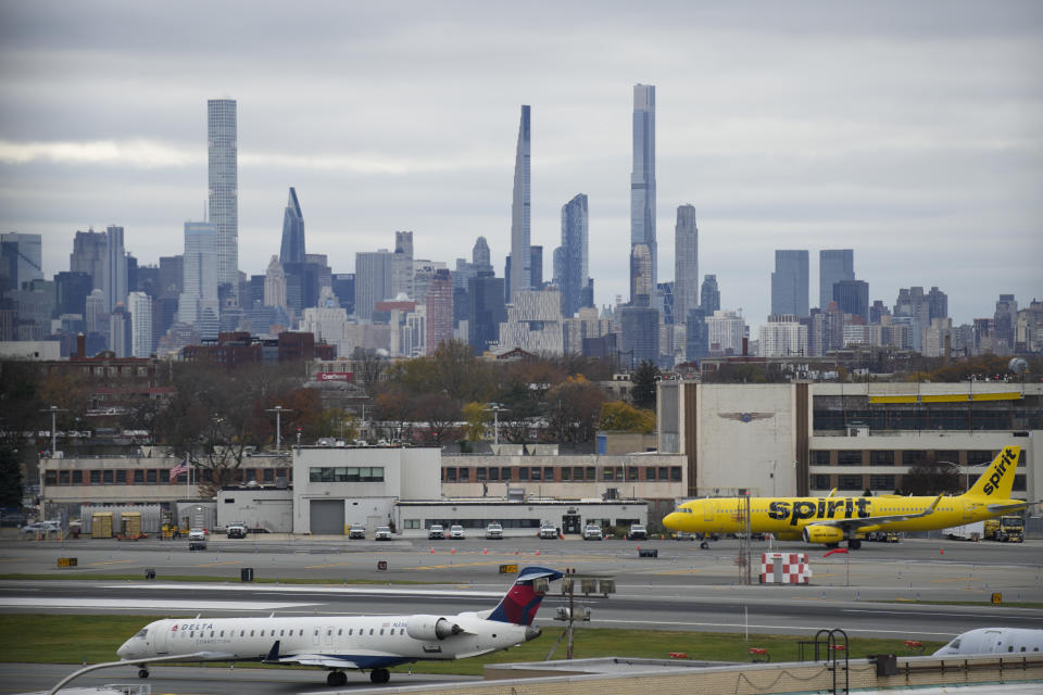 The New York City skyline is seen behind planes waiting to take off at LaGuardia Airport in New York, Wednesday, Nov. 22, 2023. (AP Photo/Seth Wenig)