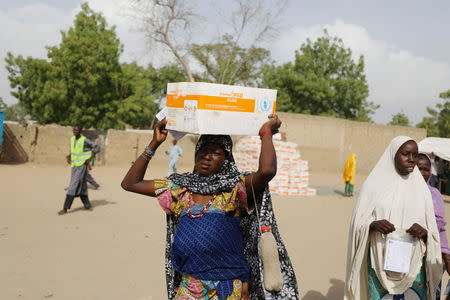 A woman carries a box of food supplement provided by World Food Programme (WFP) at the Banki IDP camp, in Borno, Nigeria April 26, 2017. Picture taken April 26, 2017. REUTERS/Afolabi Sotunde