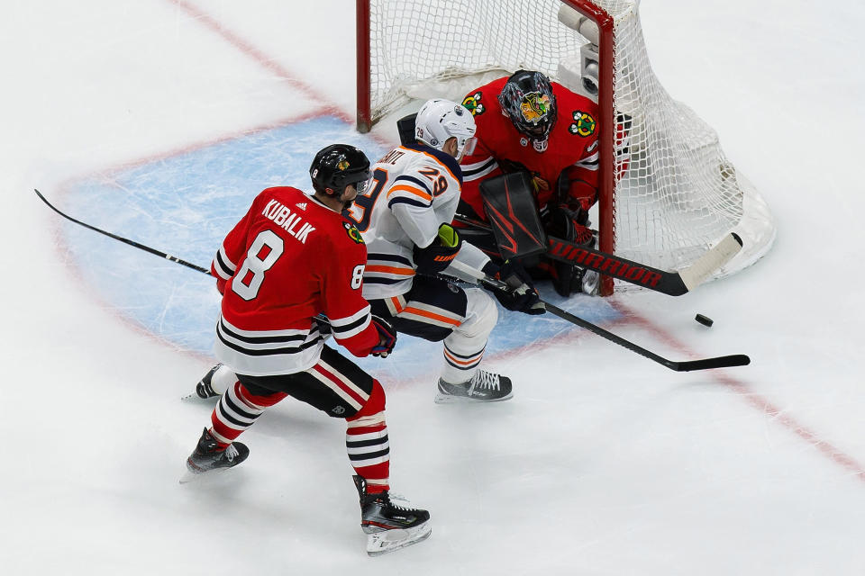 Edmonton Oilers' Leon Draisaitl (29) shoots on Chicago Blackhawks goaltender Corey Crawford (50) as Blackhawks' Dominik Kubalik (8) defends during the third period of an NHL hockey playoff game Wednesday, Aug. 5, 2020, in Edmonton, Alberta. (Codie McLachlan/The Canadian Press via AP)