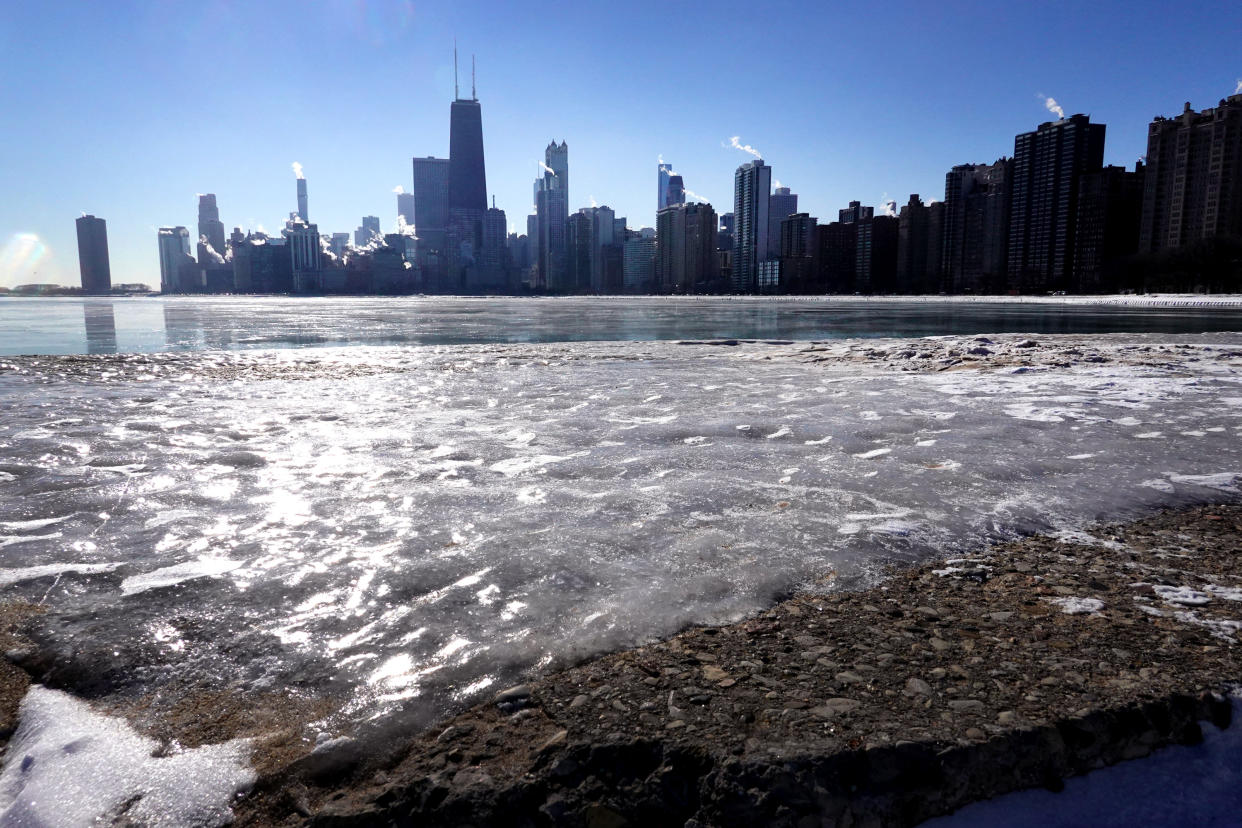 Ice forms along the shore of Lake Michigan. Chicago skyscrapers can be seen in the background.