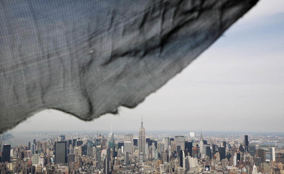 A torn safety net on One World Trade Center provides a window view of the Manhattan skyline, Monday, April 30, 2012 in New York. One World Trade Center is being built to replace the twin towers destroyed in the Sept. 11 attacks. It reached just over 1,250 feet on Monday. That's just taller than the observation deck on the Empire State Building. (AP Photo/Mark Lennihan, Pool)