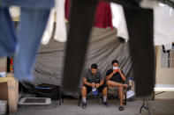 Two men from Nicaragua wait to apply for asylum in the United States Thursday, June 30, 2022, at a shelter for migrants in Tijuana, Mexico. The Supreme Court has ruled that the Biden administration properly ended a Trump-era policy forcing some U.S. asylum-seekers to wait in Mexico. (AP Photo/Gregory Bull)