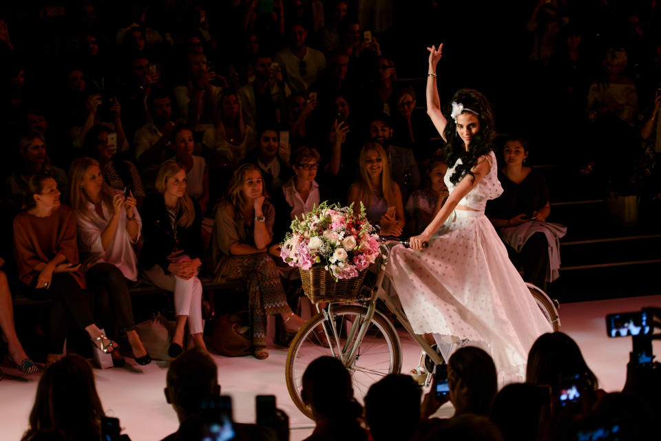 2016 sorgte Guido Maria Kretschmer für einen romantischen Start. Traditionellerweise eröffnete das Model Zoe Helali seine Show. Allerdings lief sie nicht über den Laufsteg, sondern fuhr, und zwar auf einem blumenbepackten Fahrrad. (Bild-Copyright: Clemens Bilan/Getty Images)