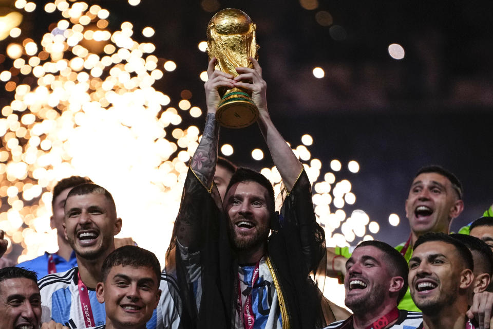 Argentina's Lionel Messi holds up the trophy after winning the World Cup final soccer match between Argentina and France at the Lusail Stadium in Lusail, Qatar, Sunday, Dec.18, 2022. (AP Photo/Manu Fernandez)