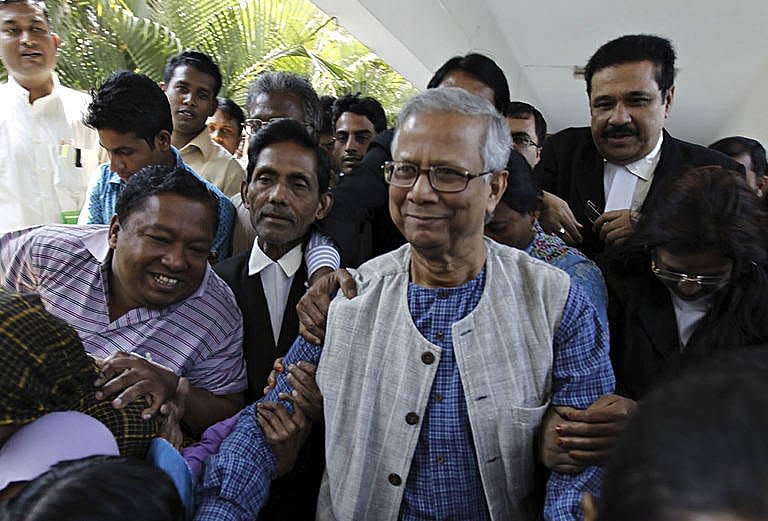 Microfinance pioneer Muhammad Yunus (centre) emergeson Thursday from the high court building where he contested the decision to remove him from his post in Grameen Bank, in Dhaka. Thousands of employees and customers of Grameen Bank protested in Bangladesh on Saturday over the sacking of the Nobel laureate as head of the microfinance institution he pioneered