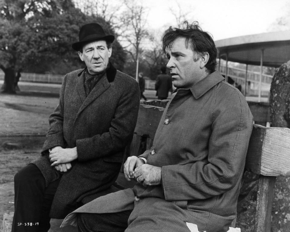 Richard Burton on bench with man in a scene from the film 'The Spy Who Came In From The Cold', 1965. (Photo by Metro-Goldwyn-Mayer/Getty Images)