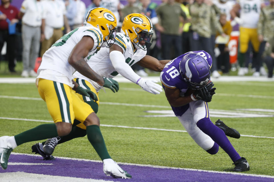 Minnesota Vikings wide receiver Justin Jefferson (18) catches a 9-yard touchdown pass ahead of Green Bay Packers cornerback Rasul Douglas, left, and safety Henry Black during the second half of an NFL football game, Sunday, Nov. 21, 2021, in Minneapolis. (AP Photo/Bruce Kluckhohn)