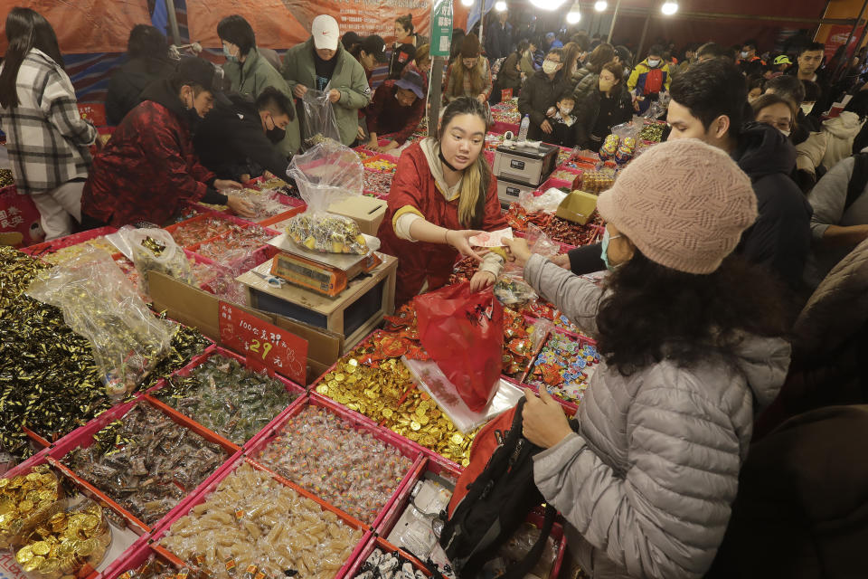 People shop for the upcoming Lunar New Year celebrations at the Dihua street market in Taipei, Taiwan, Thursday, Feb. 8, 2024. Taiwanese shoppers started hunting for delicacies, dried goods and other bargains at the market ahead of the Lunar New Year celebrations which fall on Feb. 10 this year. (AP Photo/Chiang Ying-ying)