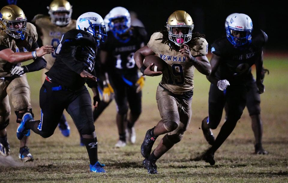 Henry Bennett (19) of Cardinal Newman breaks free for a touchdown in the fourth quarter against Pahokee on Thursday in Pahokee.