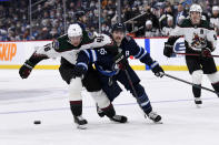 Winnipeg Jets' Mark Scheifele (55) and Arizona Coyotes' Ilya Lyubushkin (46) battle for the puck during the second period of NHL hockey game action in Winnipeg, Manitoba, Monday, Nov. 29, 2021. (Fred Greenslade/The Canadian Press via AP)