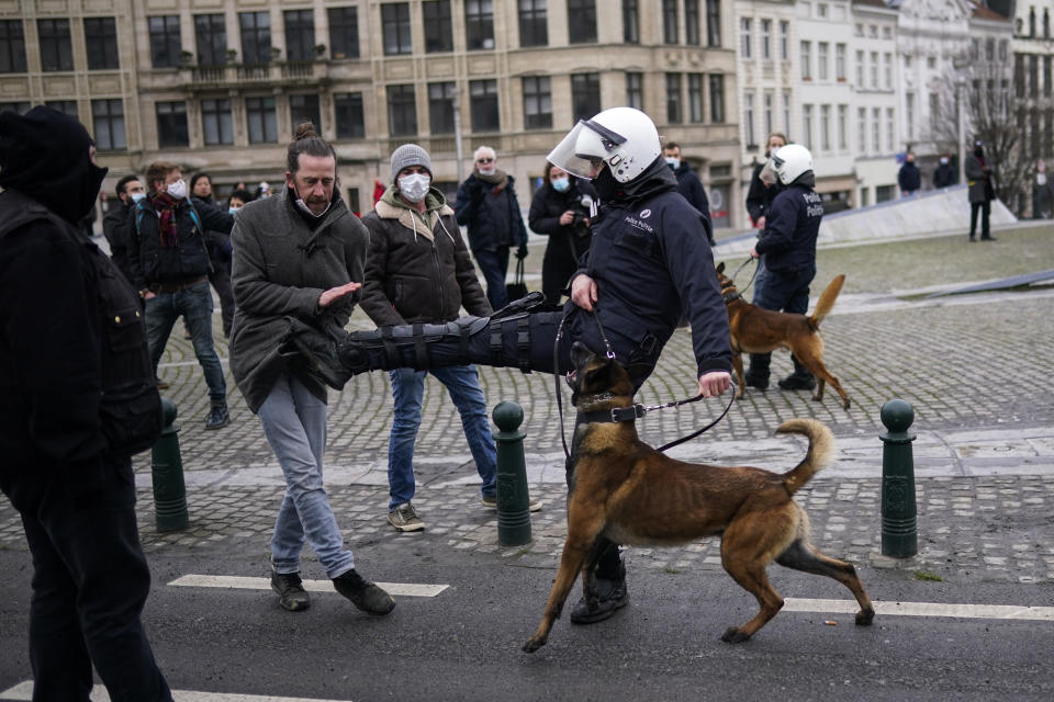 A police officer kicks a protesterduring an unauthorised demonstration against COVID-19 restrictive measures in Brussels, Sunday, Jan. 31, 2021. According to Belgian media around 200 people have been arrested for trying to join a protest against restrictive measures implemented in the country in order to fight the virus, such as a 10pm curfew or the closing of bars and restaurants. (AP Photo/Francisco Seco)