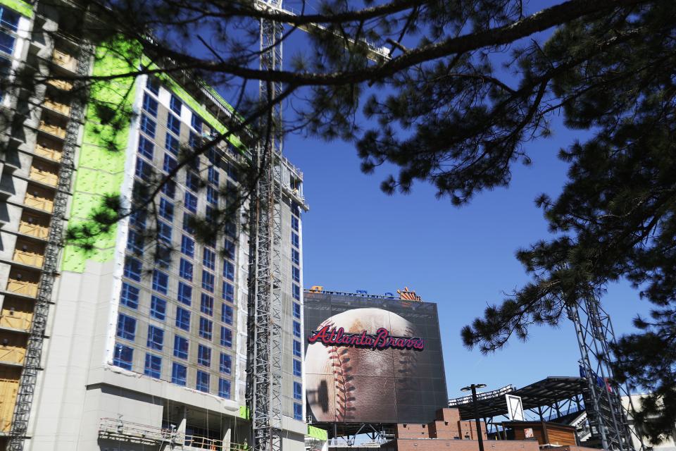 A billboard of a baseball stands next to a hotel under construction with a view into SunTrust Park in Atlanta.
