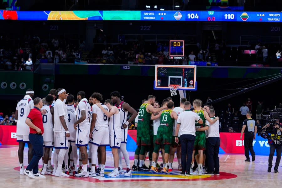 The United States team and the Lithuania team gather on the court following a 110-104 Lithuania win over the United States in a Basketball World Cup second-round match in Manila, Philippines Sunday, Sept. 3, 2023.(AP Photo/Michael Conroy)