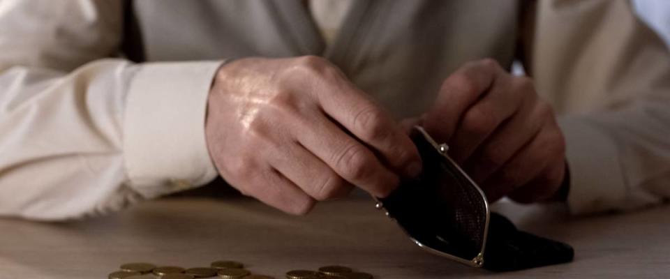 Older person putting coins into a wallet