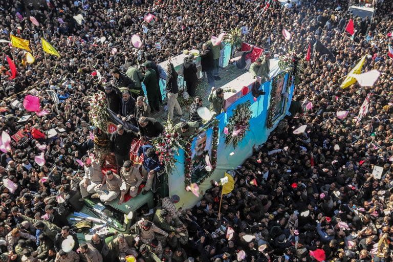 Dolientes iraníes se congregan alrededor de un vehículo que lleva el ataúd del fallecido general de alto rango Qasem Soleimani durante la etapa final de las procesiones fúnebres en su ciudad natal, Kerman, el 7 de enero de 2020. 