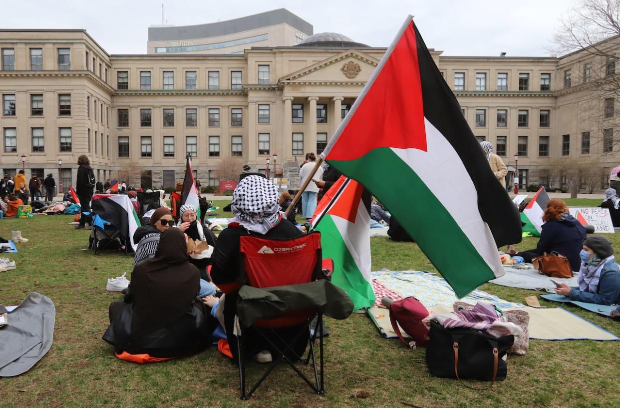 Pro-Palestinian supporters take part in a sit-in at the University of Ottawa on April 29. Protesters are calling on the university to disclose its investment portfolio and divest from companies that have ties to Israel. (Patrick Doyle/The Canadian Press - image credit)