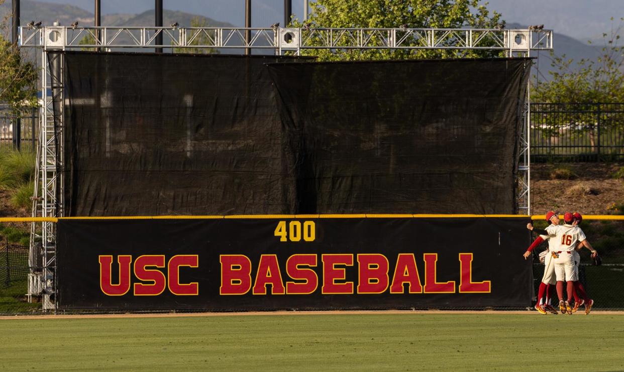 USC outfielders celebrate next to the batter's eye that was built for USC at the Great Park in Irvine on May 3.