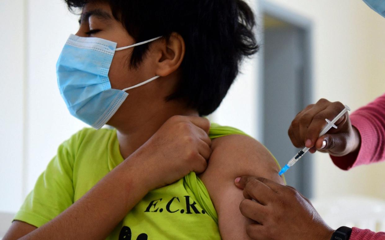 A minor receives a dose of the Pfizer-BioNTech vaccine at a vaccination center in Asuncion, on July 23, 2021. Paraguay started to inoculate children and teenagers from 12 to 17 years-old with underlying diseases. - AFP