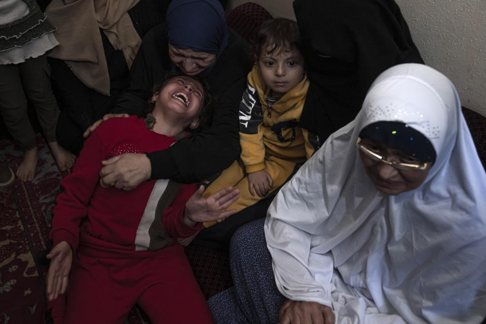 Palestinian relatives weep at the funeral for Islamic Jihad commander Ali Ghali, and his brother, Mohammed Ghali, both killed in an Israeli airstrike in Khan Younis, southern Gaza Strip, Thursday, May 11, 2023. (AP Photo/Fatima Shbair)