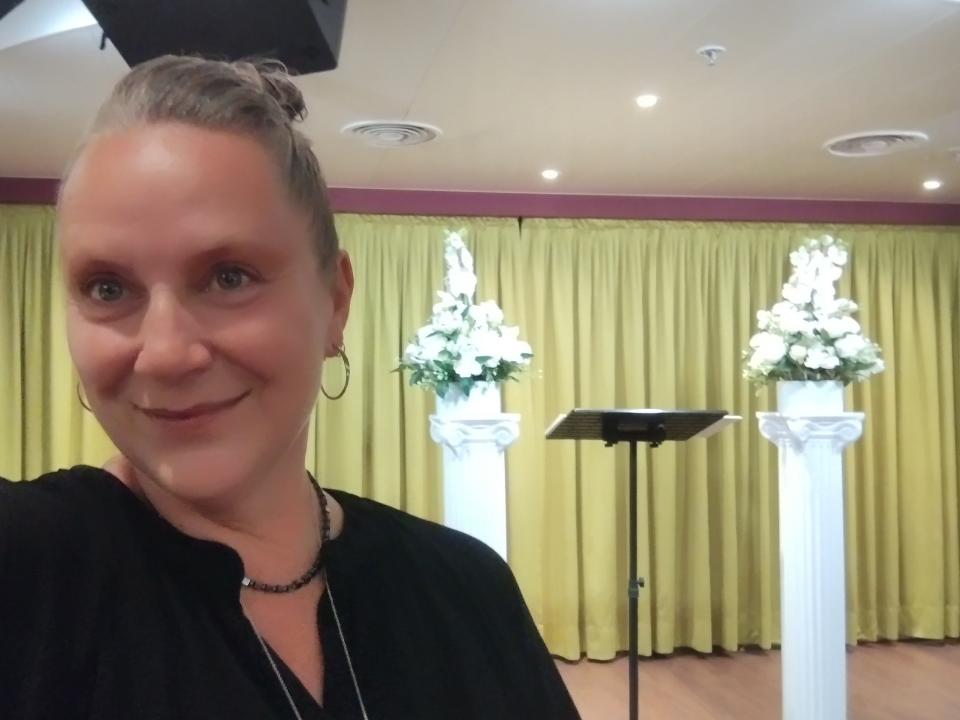 A woman posing in front of a podium.