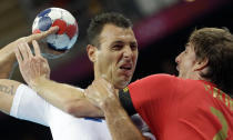 Spain's Viran Morros de Argila, right, and France's Jerome Fernandez challenge during their men's handball quarterfinal match at the 2012 Summer Olympics, Wednesday, Aug. 8, 2012, in London. (AP Photo/Matthias Schrader)