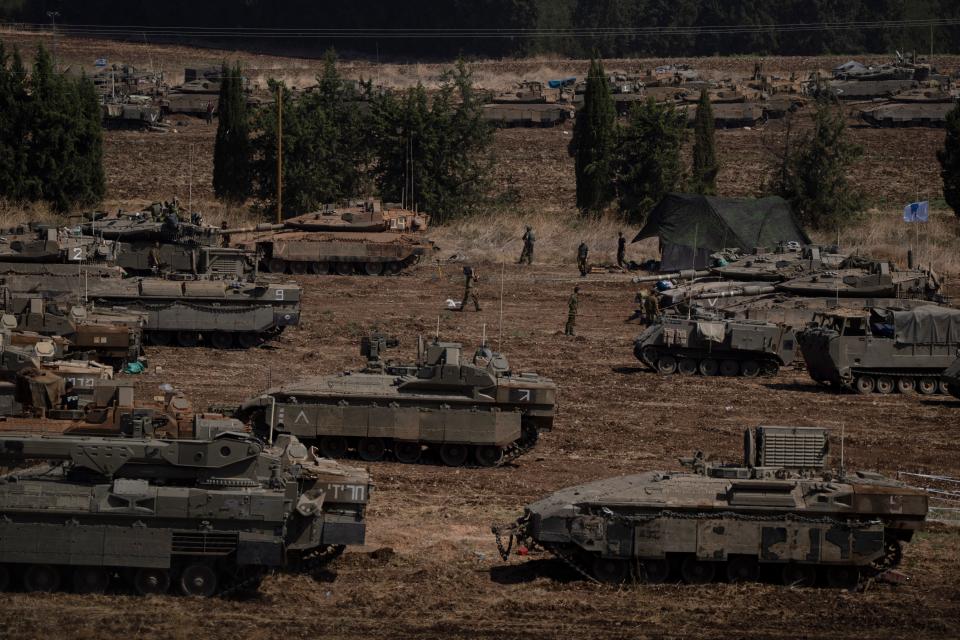 Israeli soldiers work on tanks and armored personnel carriers in northern Israel on September 30.