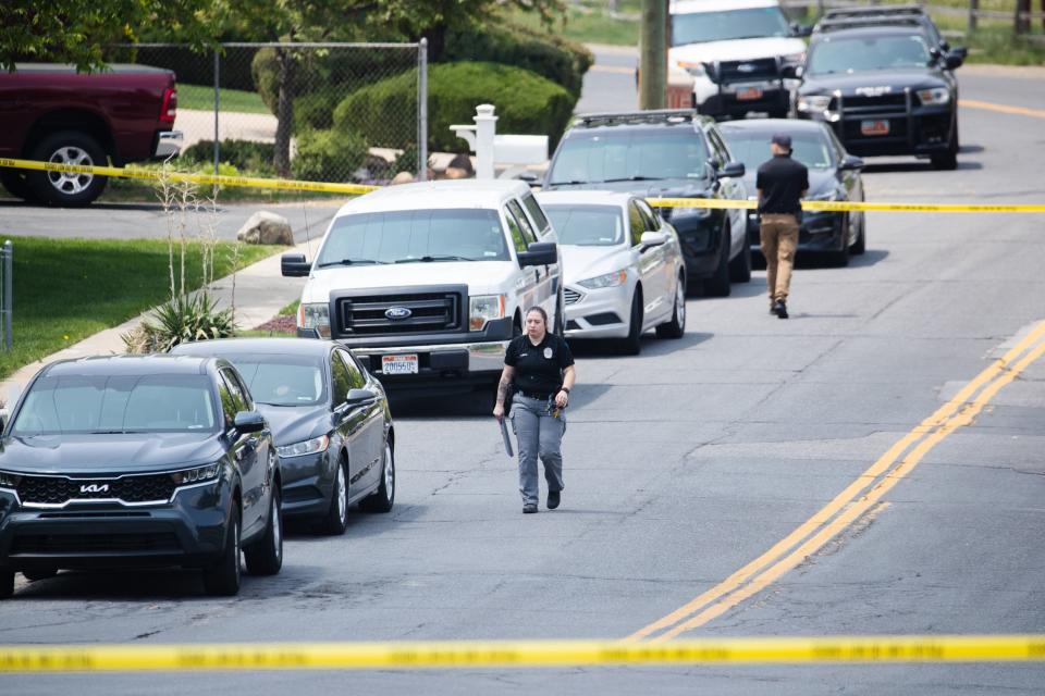 Layton Police officers walk down the street near the scene of a triple homicide in Layton on Friday, May 19, 2023. | Ryan Sun, Deseret News