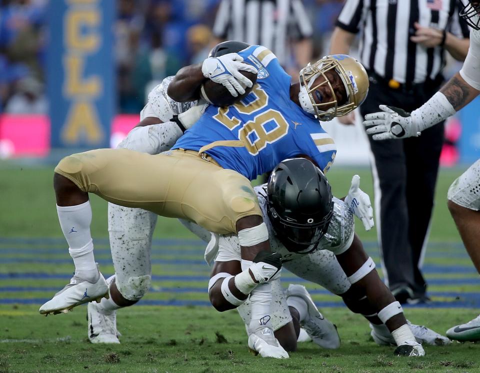 UCLA running back Brittain Brown is brough down