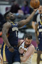 New Orleans Pelicans' Zion Williamson, left, drives to the basket against Cleveland Cavaliers' Kevin Love in the second half of an NBA basketball game, Sunday, April 11, 2021, in Cleveland. (AP Photo/Tony Dejak)