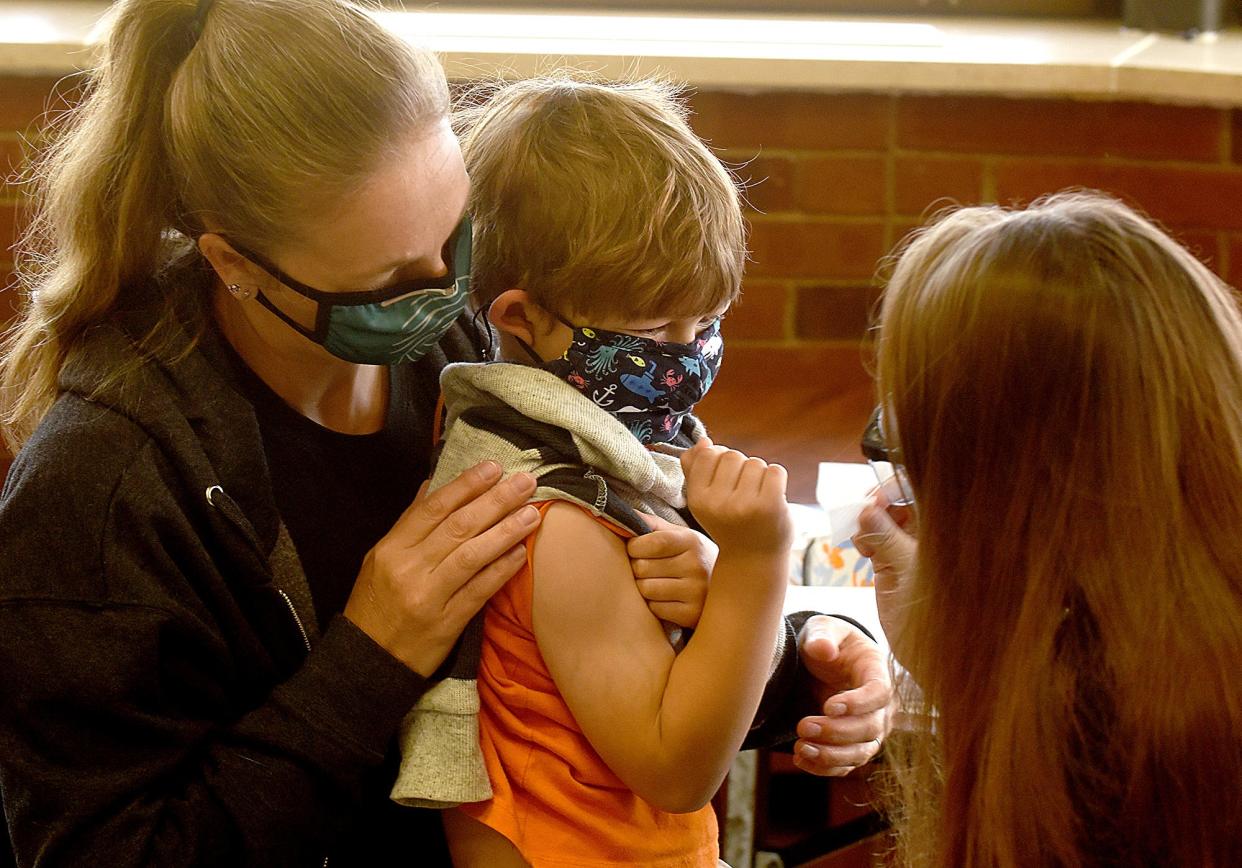 Columbia/Boone County Public Health and Human Services nurse Taylor Knoth prepares to give a COVID-19 vaccination to Stone Leonard, 5, in November as his mother, Jessica, a volunteer at Mill Creek Elementary School, holds her son.