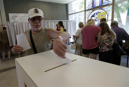 A man casts his vote during European Parliament and Lithuania's presidential elections in Vilnius May 25, 2014. REUTERS/Ints Kalnins