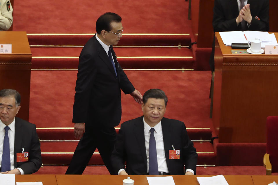 Chinese Premier Li Keqiang walks past President Xi Jinping during the opening session of China's National People's Congress (NPC) at the Great Hall of the People in Beijing, Friday, May 22, 2020. (AP Photo/Ng Han Guan, Pool)