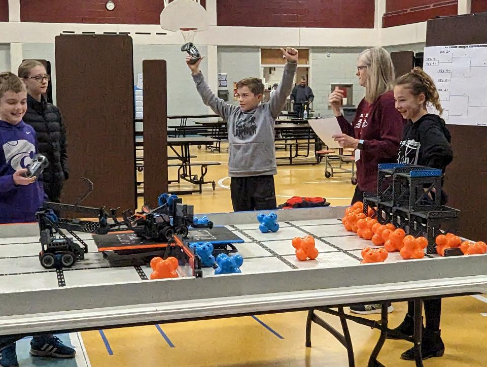 Eli Schooler celebrates after his team's robot design won a preliminary round in Silver Lake Elementary School's VEX IQ robotics competition Friday morning in the school gym.